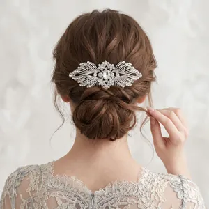 Vue détaillée d'un peigne à cheveux en strass avec ailes sur un chignon de mariée