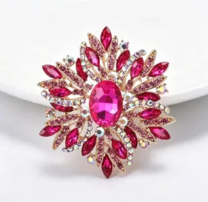Gros plan d'une grande broche étoile en cristal rose avec monture en alliage doré.