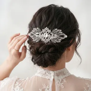 Peigne à cheveux de mariage élégant en forme d'aile argentée avec des strass étincelants.