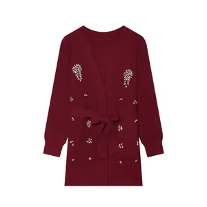 Vue détaillée d'un élégant gilet en tricot bordeaux avec des perles en strass argentés