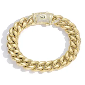 Macro detail of a 14K gold-plated Cuban link bracelet with iced-out stone clasp
