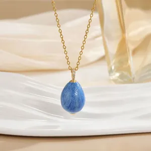 Gold-plated necklace with a marbled blue Easter egg pendant and sparkling zircon detail.
