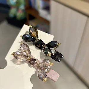 Close-up of elegant bow-shaped hair clips with shimmering crystals and rhinestones.