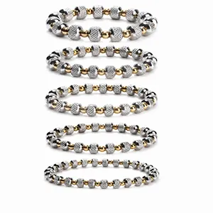 Detailed view of five stacked stainless steel bracelets with silver and gold beads
