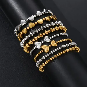 Detail view of heart and bow charm stainless steel stretch bracelets in gold and silver