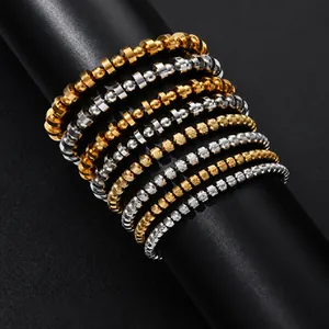 Close-up of stacked stainless steel beaded bracelets with mesh pattern in gold and silver.