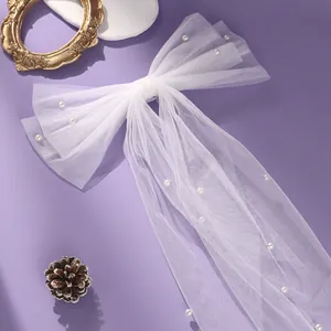 Elegant white tulle bow hair clip with pearls for wedding or romantic party hairstyles