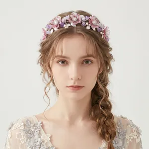Detailed view of floral headband with pink acrylic flowers and pearls on a model