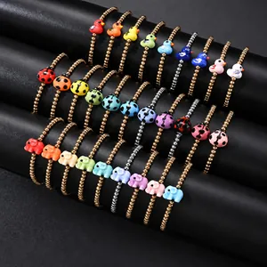 Close-up detail of colorful beaded bracelets featuring cute duck and elephant charms.