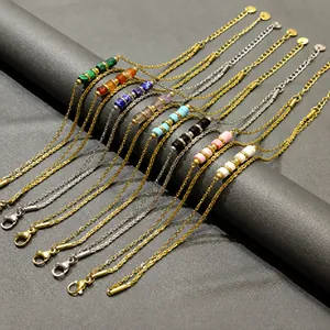 Assorted multi-color beaded titanium steel bracelets displayed on a dark display roll.