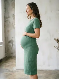 Détail de profil latéral d'une robe de maternité verte à manches courtes en coton ajustée