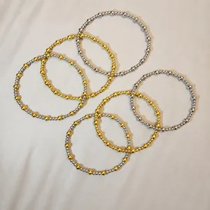 Detail view of multi-layer mixed metal gold and silver beaded stretch bracelets