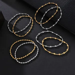 Detailed view of mixed metal elastic bead bracelets in polished gold and silver finishes.