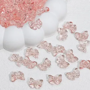 Macro detail of transparent pink bow-shaped glass beads for jewelry making
