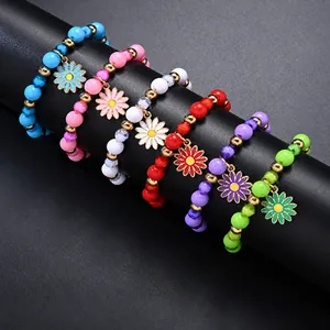 Macro detail of colorful matte soft clay beaded elastic bracelets with daisy charms