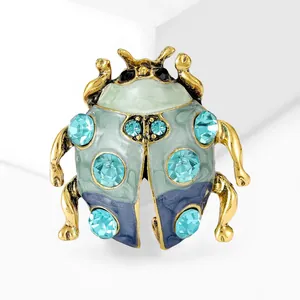 Close-up van vintage lieveheersbeestje broche met blauwe kristallen en emaille details