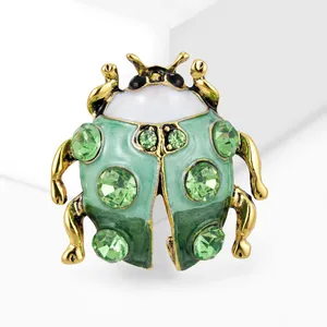 Macro-opname van een groene keverbroche met goudkleurige afwerking en kristallen details