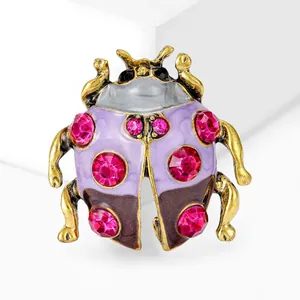 Macro detail van een legering kever broche met levendige roze strassteentjes en glazuur.
