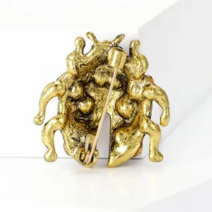 Gedetailleerd achteraanzicht van antieke gouden keverknoopspeld met veiligheidssluiting