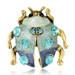 Elegante vintage kever broche met blauwe kristallen en groen email op goudkleurige legering