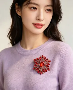 Close-up view of a luxury elegant red sunburst crystal rhinestone brooch pin on a sweater