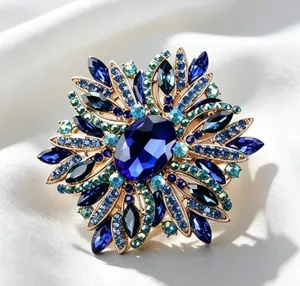 Close-up of elegant blue crystal brooch with radiant rhinestone floral design on silk