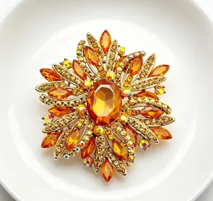 Detailed macro view of luxury flower sunburst brooch with amber crystals and gold tone