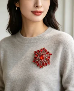 Close-up of elegant red crystal rhinestone brooch on a grey wool sweater detail