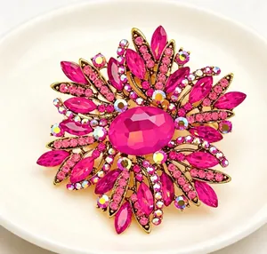 Close-up of luxurious fuchsia crystal flower brooch with gold-tone metal frame