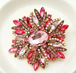 Detailed macro view of an elegant sunburst flower brooch with pink and red crystals