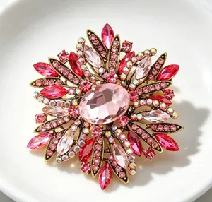 Detail of luxury floral brooch featuring large pink crystals and vintage gold tone finish