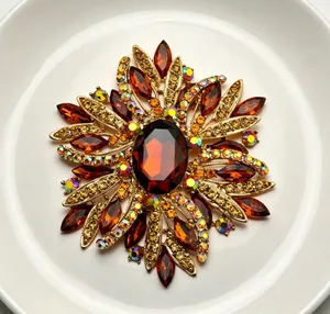 Close-up of elegant amber crystal brooch with intricate rhinestone floral design