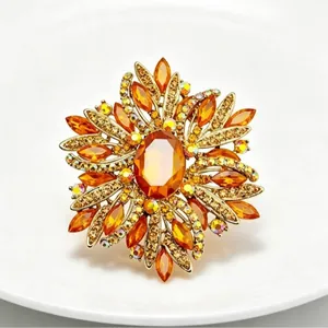 Elegant golden flower brooch with sparkling amber crystals and rhinestones for suits
