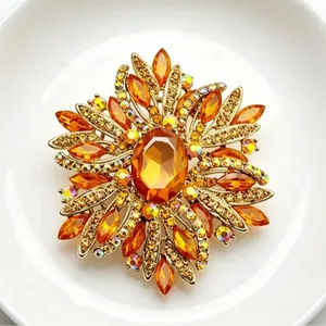 Elegant luxury star-shaped gold brooch featuring vibrant orange crystals and rhinestones