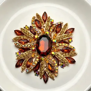 Elegant vintage starburst brooch with amber crystals and sparkling rhinestones