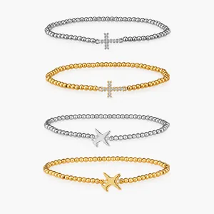 Detail showing four mixed stainless steel beaded bracelets in gold and silver finishes.