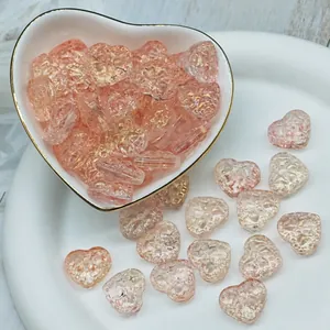 Macro view of pink heart-shaped glass beads with gold foil details for DIY jewelry