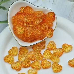 Dettaglio ravvicinato di perline di vetro ambrato a forma di cuore per gioielli fatti a mano DIY