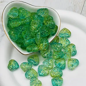 Detailed macro view of 14x16x7mm green heart glass beads for DIY jewelry making.