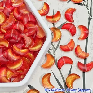 Macro view of red moon-shaped glass beads with gold foil for DIY jewelry making.