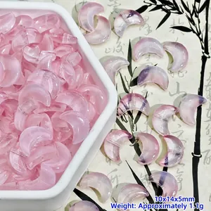 Macro view of pink moon-shaped glass beads for handmade jewelry making and DIY crafts