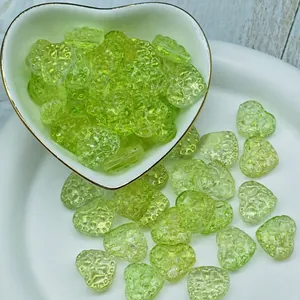 Macro view of textured 14x16mm translucent green heart-shaped glass beads for DIY crafts