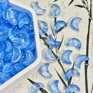 Close-up detail of translucent blue moon-shaped glass beads for DIY jewelry making, 10x14x5mm
