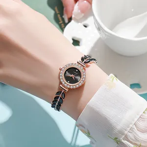 Close-up of ladies jewelry watch with black leaf-shaped crystal strap and diamond bezel