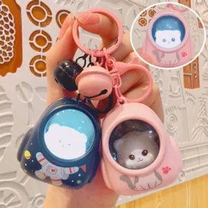 Detalle de dos bonitos llaveros de gato astronauta con luz en rosa y azul