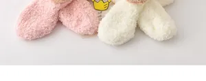Détail de la texture douce et pelucheuse des accessoires d'hiver pour enfants roses et crème