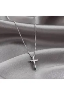 Close-up of a minimalist S925 sterling silver cross pendant on elegant silk fabric