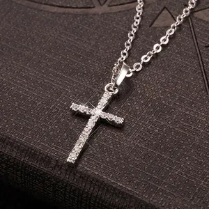 Close-up of a silver-toned cross pendant necklace inlaid with sparkling white zircons.