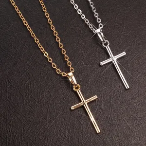 Close-up detail of gold and silver polished cross pendant necklaces on dark leather