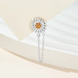 Close-up of silver sunflower stud earring with orange stones and tassel chain detail